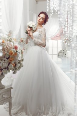 The beautiful woman posing in a wedding dress