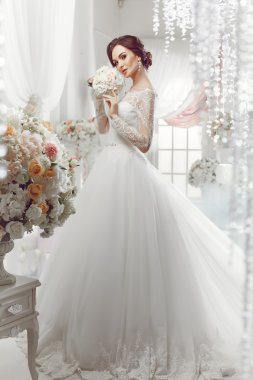 The beautiful woman posing in a wedding dress