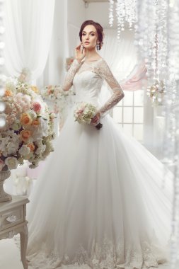 The beautiful woman posing in a wedding dress