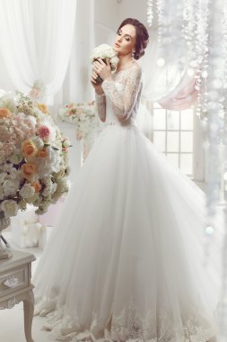 The beautiful woman posing in a wedding dress clipart