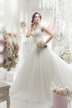 The beautiful woman posing in a wedding dress