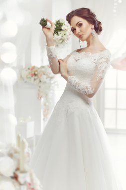 The beautiful woman posing in a wedding dress