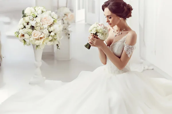 The beautiful woman posing in a wedding dress