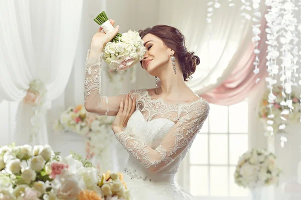 La bella donna in posa in un abito da sposa — Foto Stock