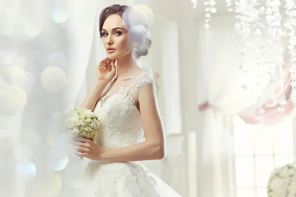 The beautiful woman posing in a wedding dress — Stok fotoğraf