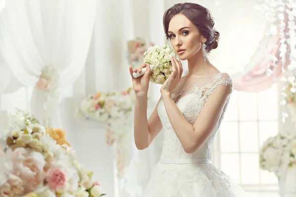 La bella donna in posa in un abito da sposa — Foto Stock