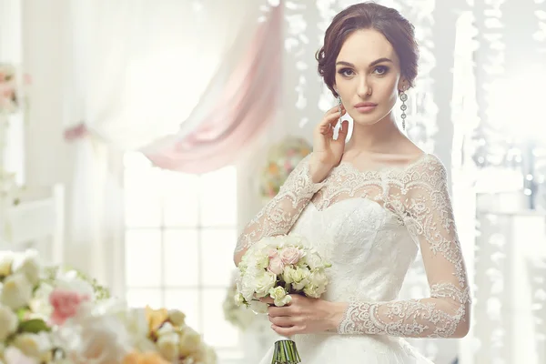 Die schöne Frau posiert im Hochzeitskleid — Stockfoto