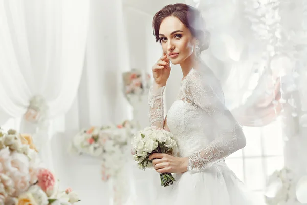 La bella donna in posa in un abito da sposa — Foto Stock