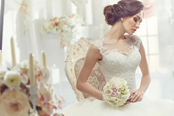 The beautiful woman posing in a wedding dress