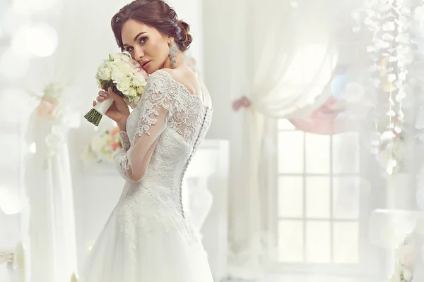 La bella donna in posa in un abito da sposa — Foto Stock