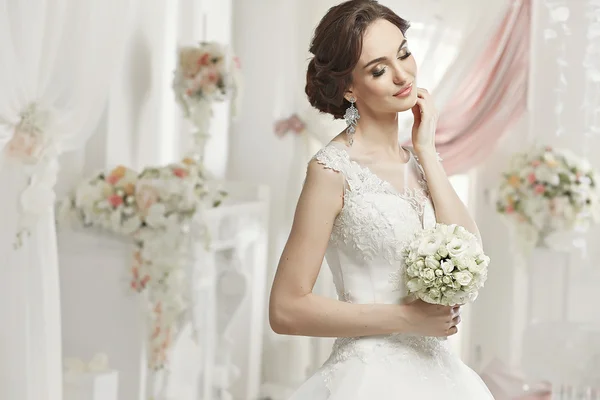 The beautiful woman posing in a wedding dress — Stok fotoğraf