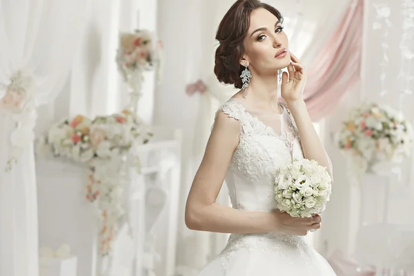 La bella donna in posa in un abito da sposa — Foto Stock