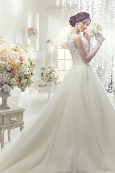 The beautiful woman posing in a wedding dress — Stock Photo, Image