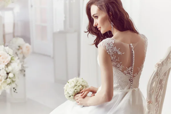 The beautiful woman posing in a wedding dress