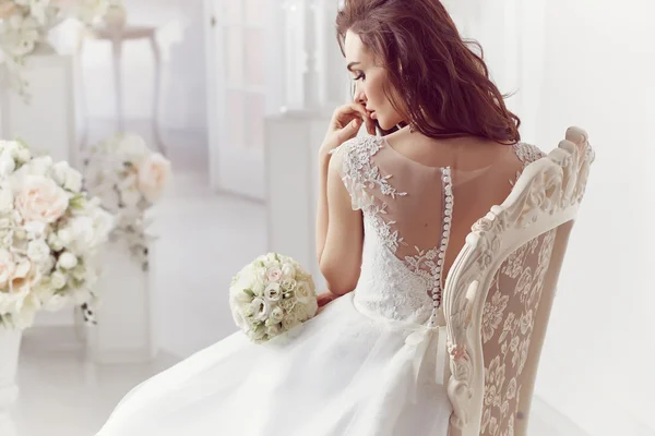 The beautiful woman posing in a wedding dress — Stock Photo, Image