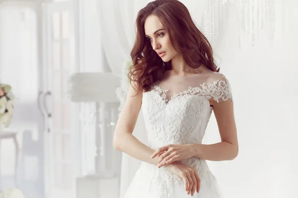 Die schöne Frau posiert im Hochzeitskleid — Stockfoto