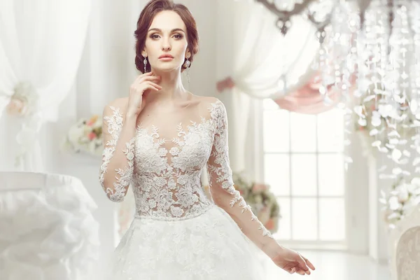 The beautiful woman posing in a wedding dress — Stock Photo, Image