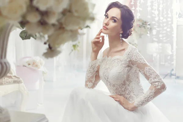 La bella donna in posa in un abito da sposa — Foto Stock