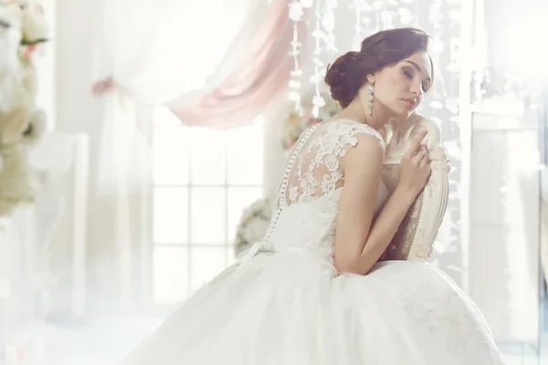 The beautiful woman posing in a wedding dress — Stok fotoğraf