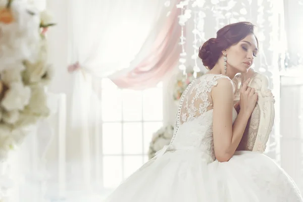 The beautiful woman posing in a wedding dress — Stok fotoğraf