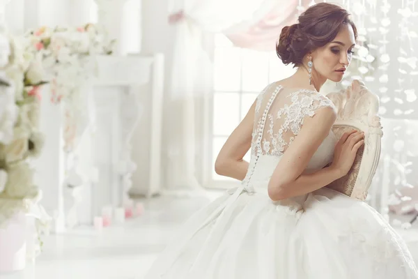 The beautiful woman posing in a wedding dress — Stock Photo, Image