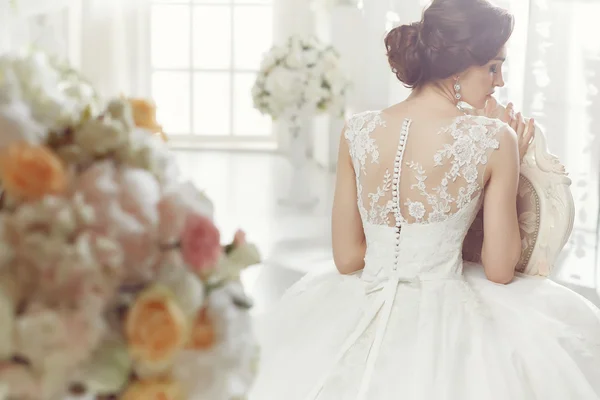 The beautiful woman posing in a wedding dress — Stok fotoğraf