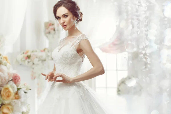 La bella donna in posa in un abito da sposa — Foto Stock