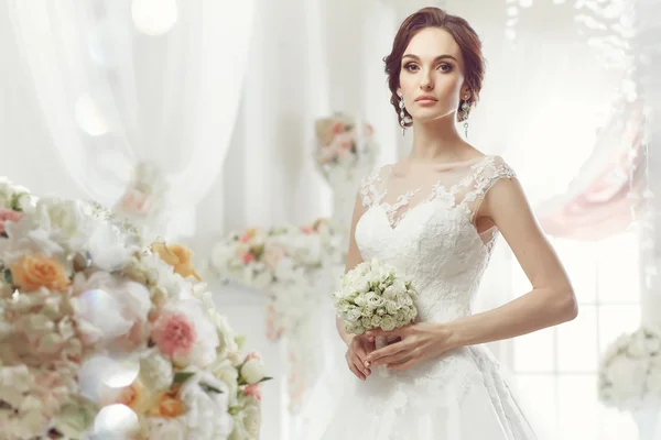 The beautiful woman posing in a wedding dress — Stok fotoğraf