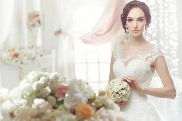 The beautiful woman posing in a wedding dress — 스톡 사진