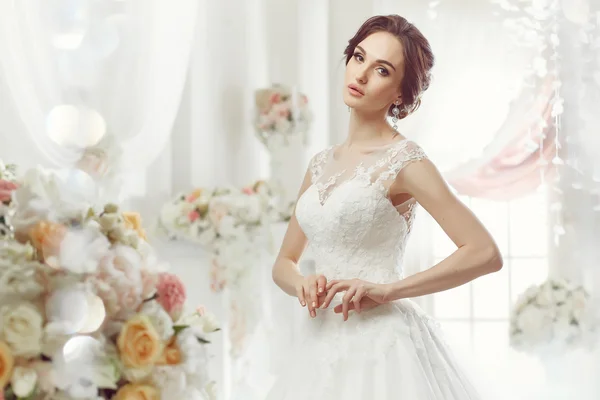 The beautiful woman posing in a wedding dress