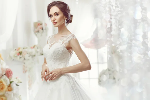 The beautiful woman posing in a wedding dress — Stock Photo, Image