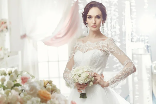 La bella donna in posa in un abito da sposa — Foto Stock