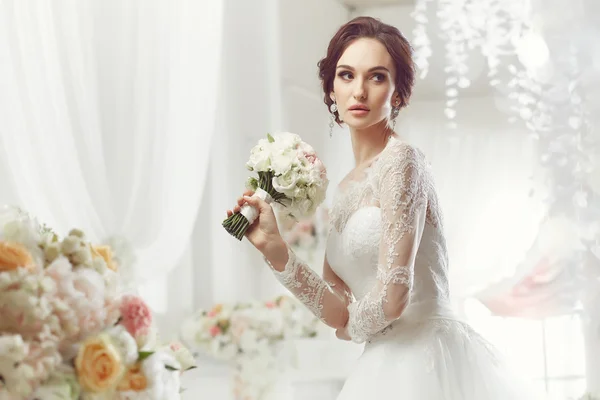 La bella donna in posa in un abito da sposa — Foto Stock