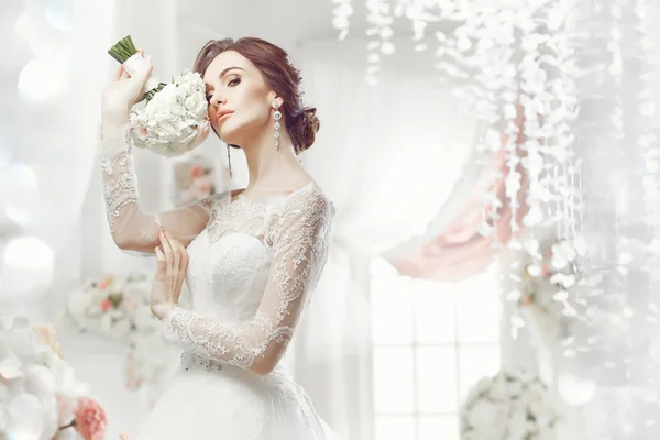 The beautiful woman posing in a wedding dress — Stok fotoğraf