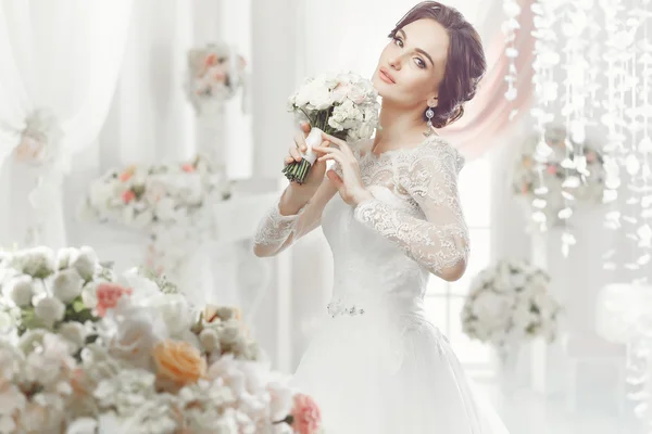 The beautiful woman posing in a wedding dress — Stok fotoğraf