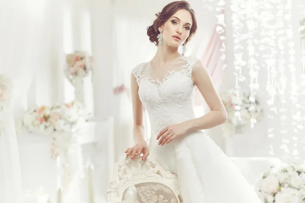 The beautiful woman posing in a wedding dress — Stock Photo, Image