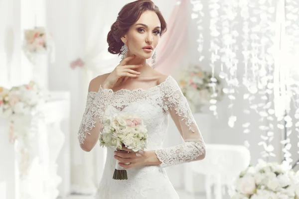 La bella donna in posa in un abito da sposa — Foto Stock