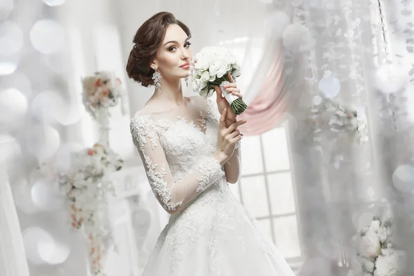 The beautiful woman posing in a wedding dress — Stock Photo, Image