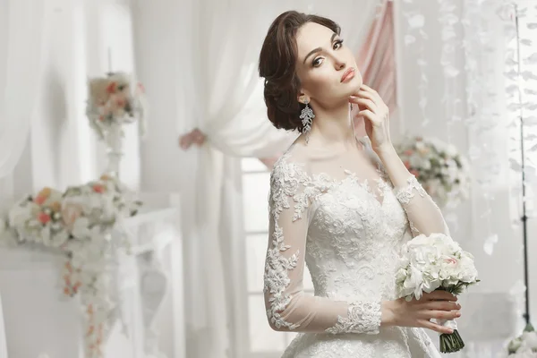 La bella donna in posa in un abito da sposa — Foto Stock