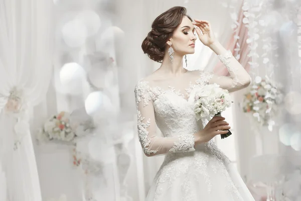 La bella donna in posa in un abito da sposa — Foto Stock