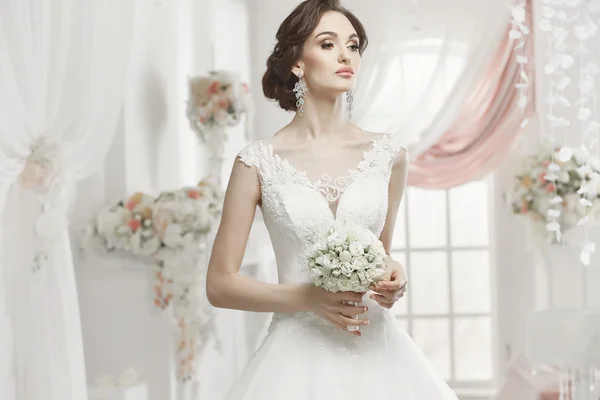 The beautiful woman posing in a wedding dress — Stok fotoğraf