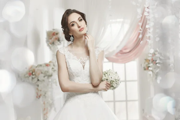 The beautiful woman posing in a wedding dress — Stok fotoğraf