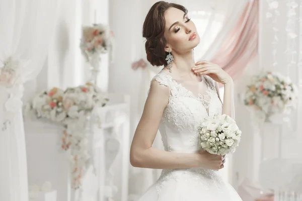 The beautiful woman posing in a wedding dress — Stok fotoğraf