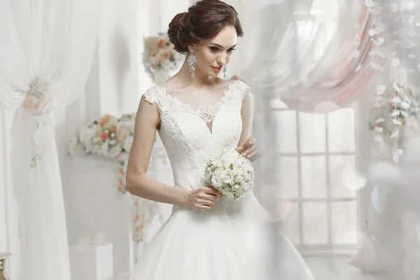 The beautiful woman posing in a wedding dress — Stok fotoğraf