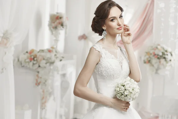 The beautiful woman posing in a wedding dress — Stok fotoğraf