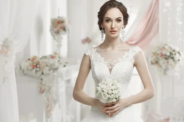 The beautiful woman posing in a wedding dress — Stok fotoğraf