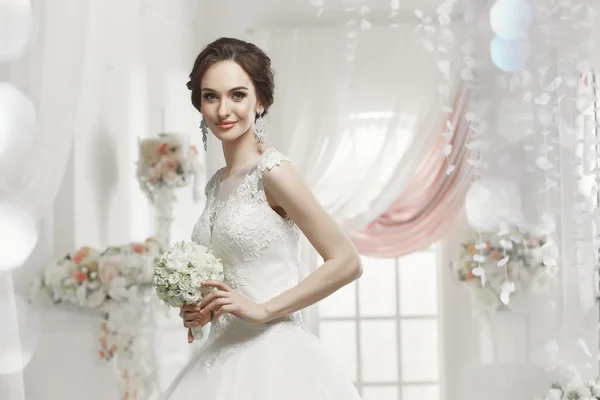 The beautiful woman posing in a wedding dress — Stok fotoğraf