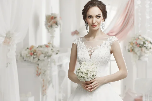 La bella donna in posa in un abito da sposa — Foto Stock