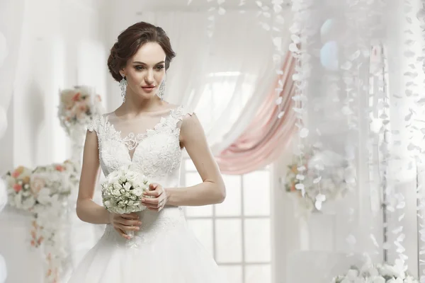 The beautiful woman posing in a wedding dress — Stock Photo, Image