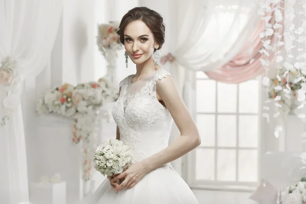 The beautiful woman posing in a wedding dress — Stok fotoğraf